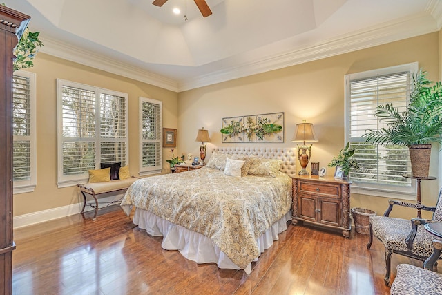 bedroom featuring crown molding, hardwood / wood-style floors, ceiling fan, and a tray ceiling