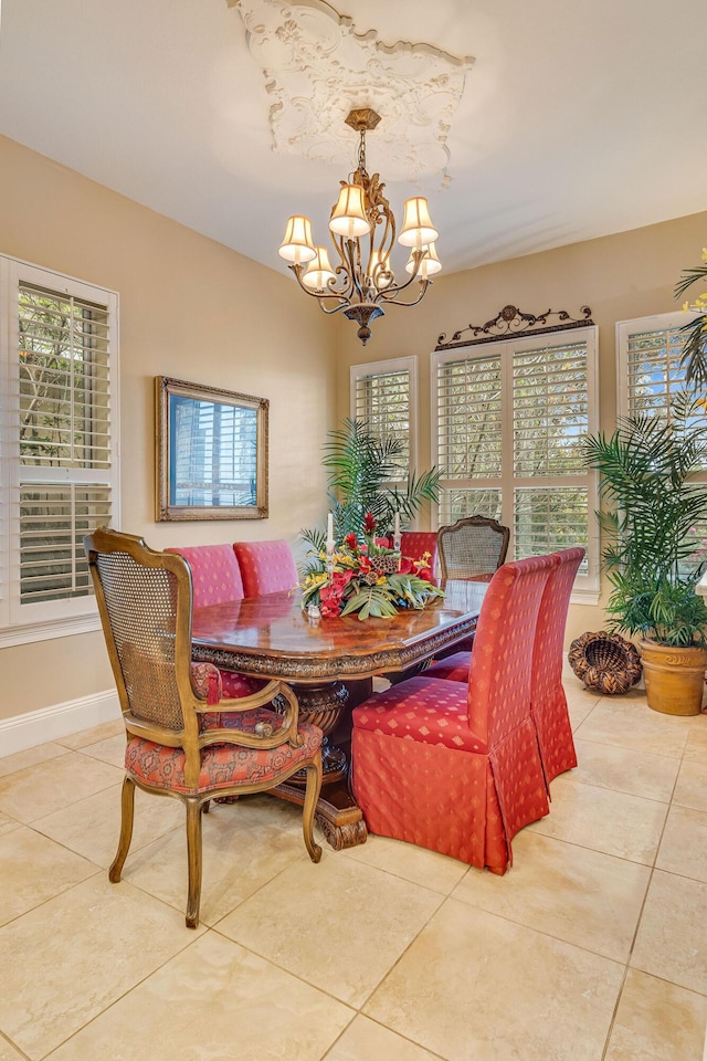 tiled dining area with plenty of natural light and a notable chandelier