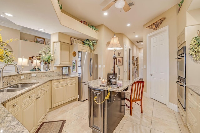 kitchen featuring light stone countertops, appliances with stainless steel finishes, sink, and an island with sink