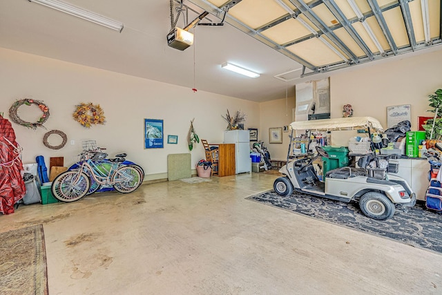 garage featuring a garage door opener and white fridge