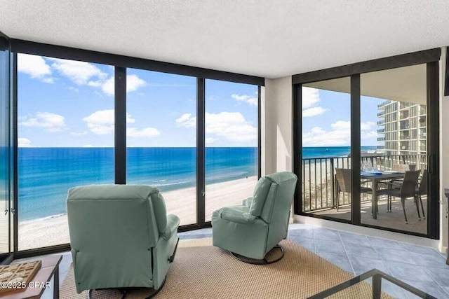 sunroom / solarium with a view of the beach and a water view