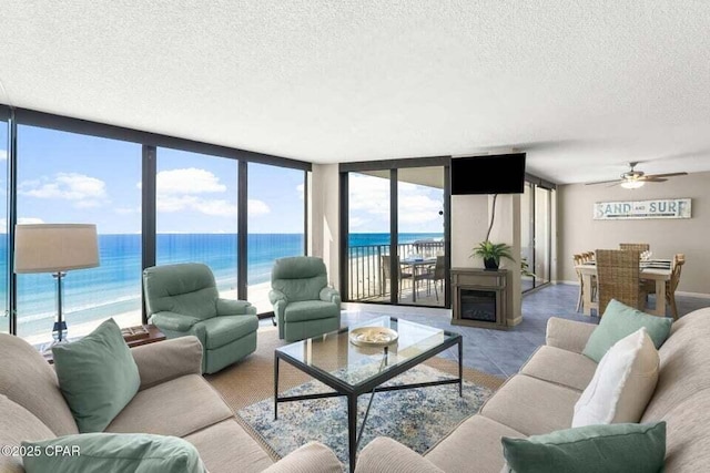 living room with ceiling fan, floor to ceiling windows, and a textured ceiling