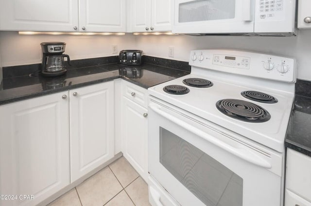 kitchen with white appliances, white cabinets, and light tile patterned flooring