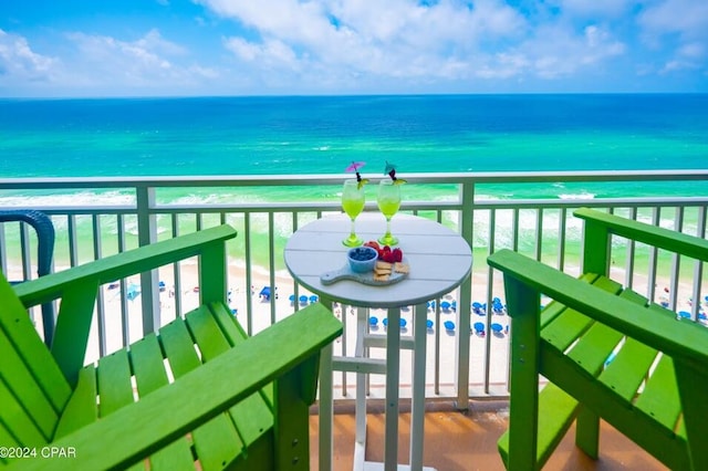 balcony with a water view and a view of the beach