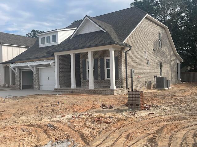 view of front of property featuring central AC and a garage