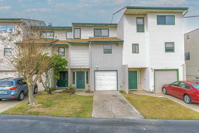 multi unit property featuring a garage and a front yard