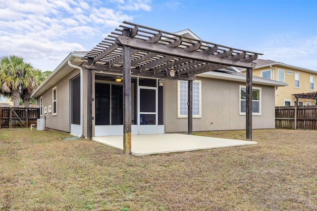 back of property featuring a sunroom, a pergola, a patio area, and a lawn