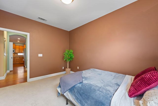 bedroom with stainless steel fridge and carpet