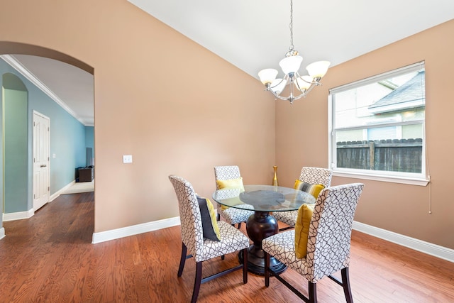 dining room featuring crown molding, a notable chandelier, and hardwood / wood-style flooring