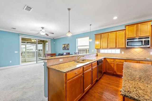 kitchen with pendant lighting, sink, decorative backsplash, ornamental molding, and kitchen peninsula