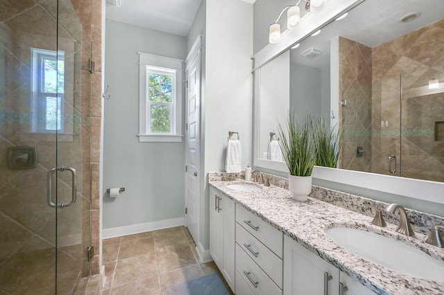 bathroom featuring a shower with door, vanity, and tile patterned flooring