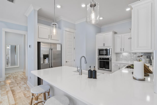 kitchen with stainless steel appliances, hanging light fixtures, and white cabinets