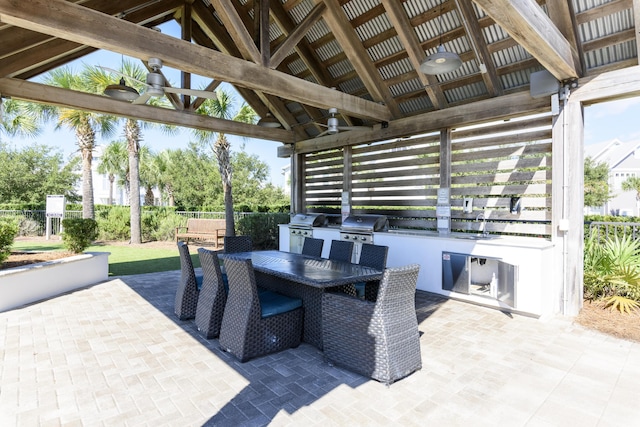 view of patio / terrace featuring a gazebo, ceiling fan, exterior kitchen, and area for grilling