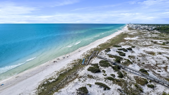 drone / aerial view featuring a water view and a view of the beach