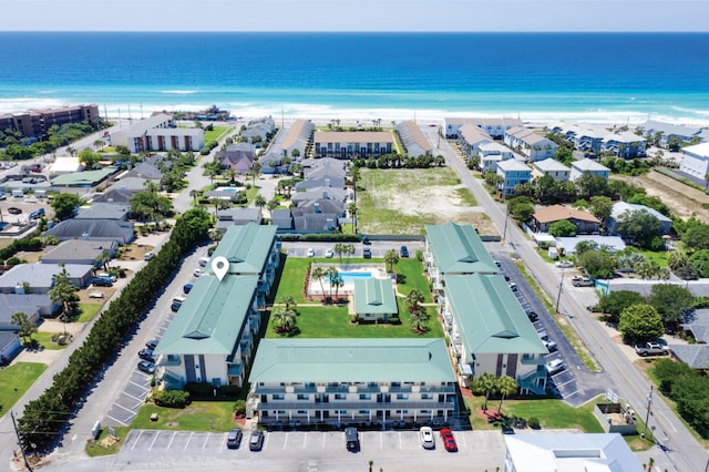 drone / aerial view featuring a residential view, a water view, and a beach view