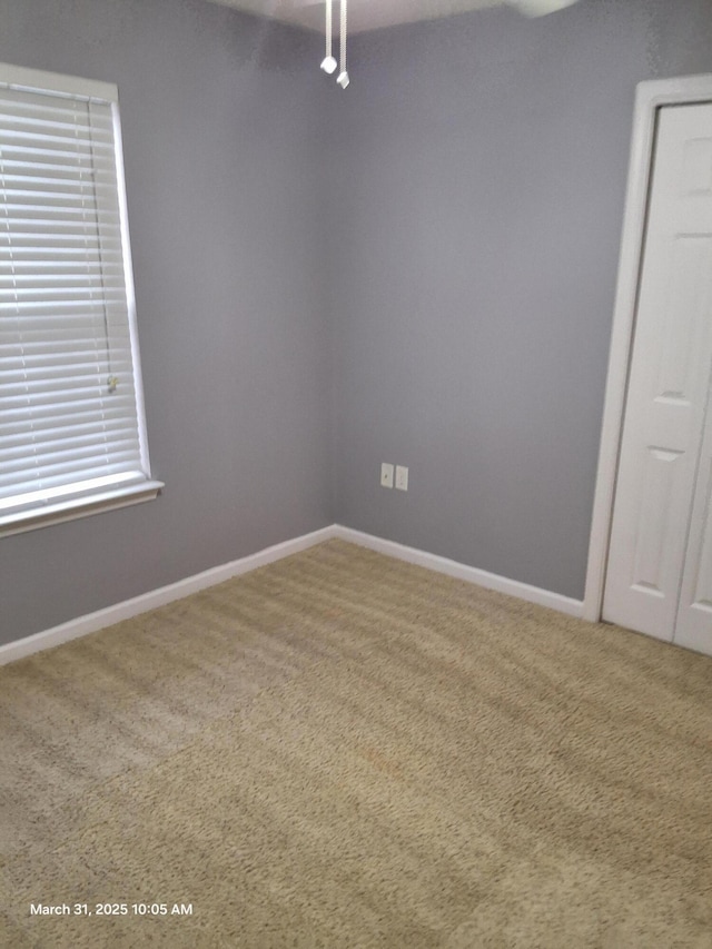 carpeted empty room with baseboards
