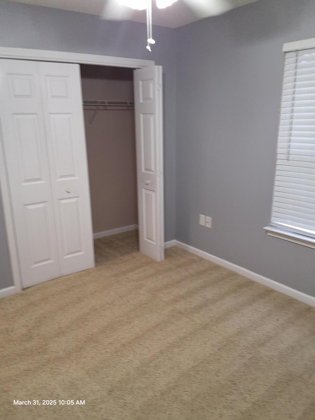 unfurnished bedroom with light carpet, baseboards, a closet, and ceiling fan