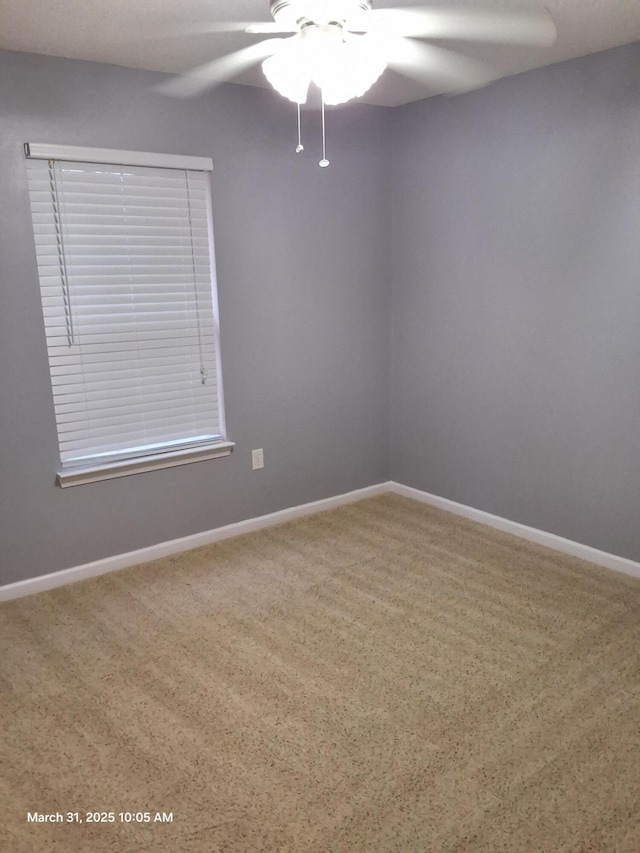 spare room with baseboards and a ceiling fan