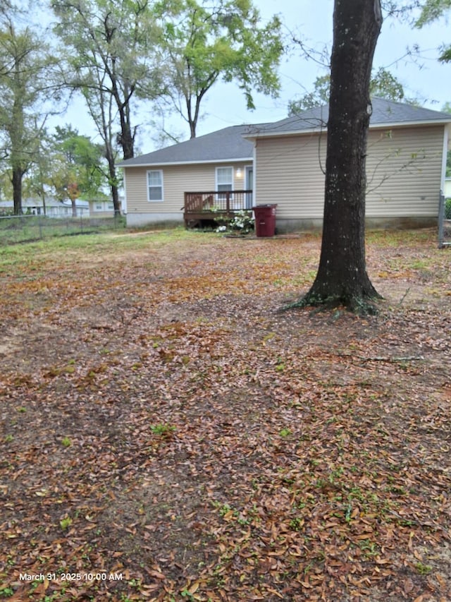 rear view of property featuring fence and a deck