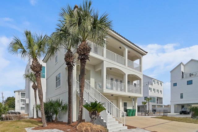 view of property featuring stairs and concrete driveway