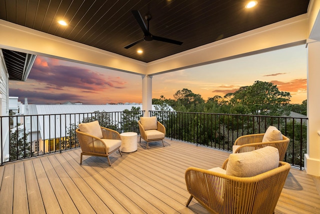 deck at dusk featuring ceiling fan