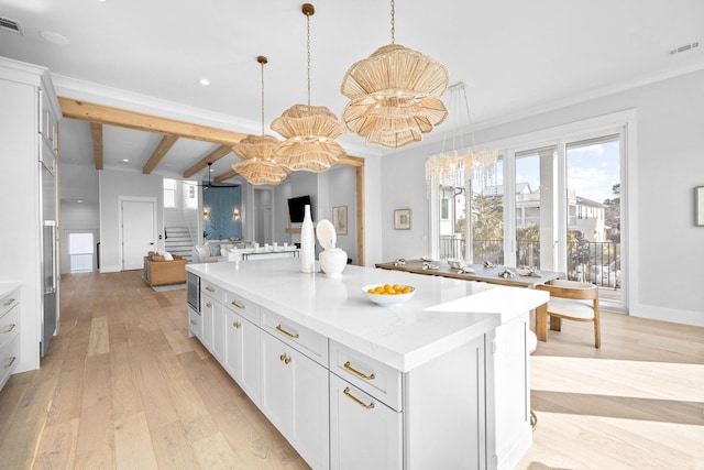 kitchen featuring white cabinetry, hanging light fixtures, beam ceiling, light hardwood / wood-style floors, and a kitchen island