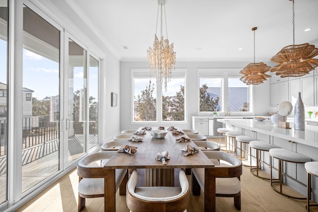 dining space featuring breakfast area, ornamental molding, light hardwood / wood-style floors, and a wealth of natural light