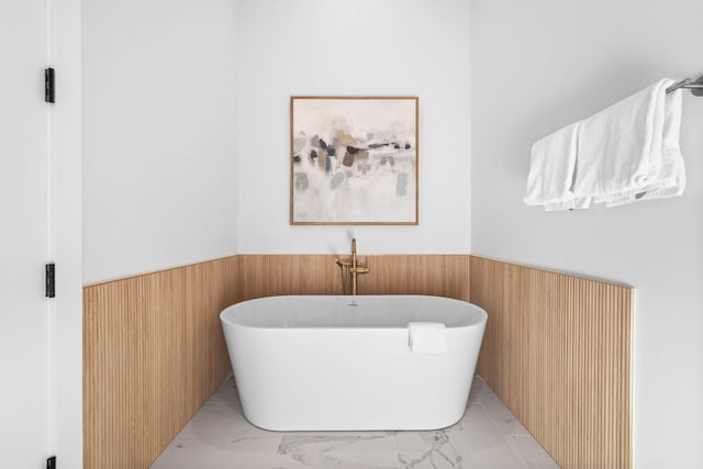 bathroom featuring a tub to relax in and wood walls