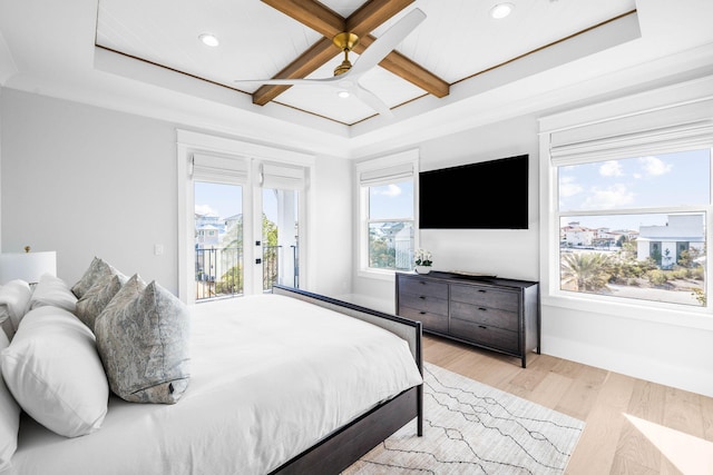 bedroom with coffered ceiling, beam ceiling, a raised ceiling, access to exterior, and light hardwood / wood-style floors