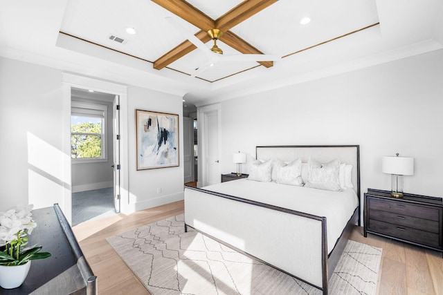 bedroom with beamed ceiling, ornamental molding, coffered ceiling, ceiling fan, and light wood-type flooring