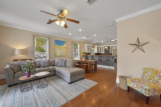 living room with crown molding, dark hardwood / wood-style floors, and ceiling fan