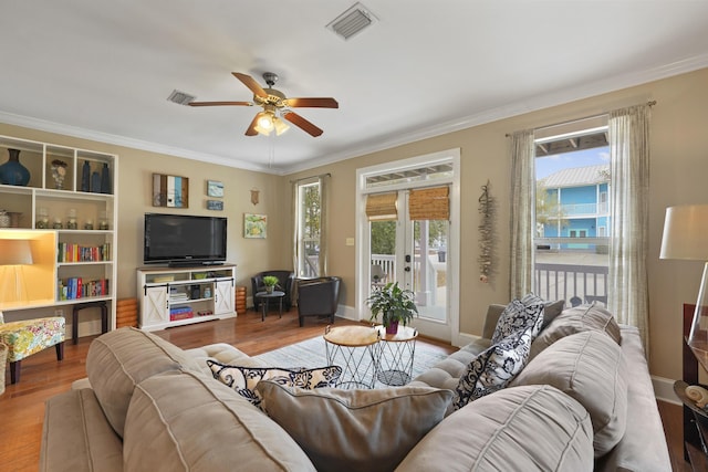 living room with crown molding, ceiling fan, hardwood / wood-style floors, and french doors