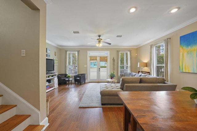 living room featuring dark wood-type flooring, ornamental molding, french doors, and a healthy amount of sunlight