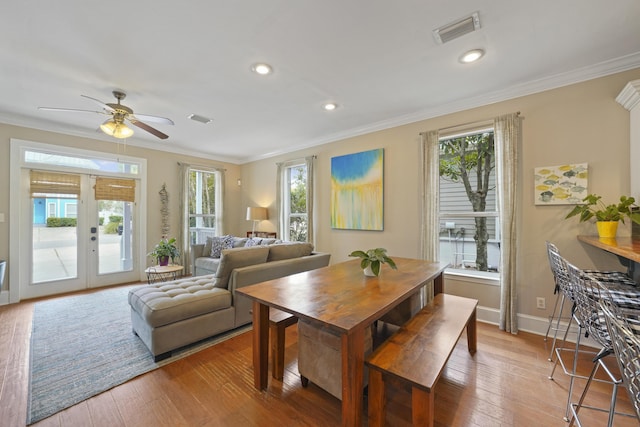 dining area featuring ornamental molding, light hardwood / wood-style floors, and french doors