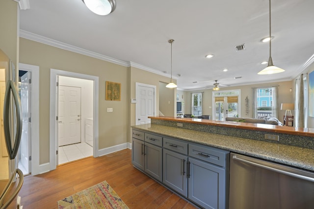 kitchen featuring stainless steel appliances, crown molding, light wood-type flooring, and decorative light fixtures