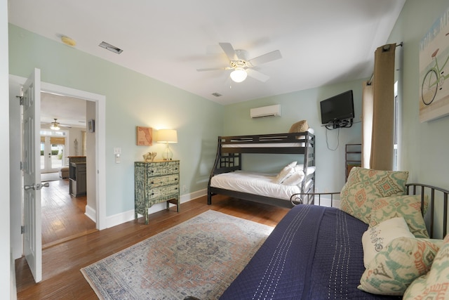 bedroom with wood-type flooring, an AC wall unit, and ceiling fan