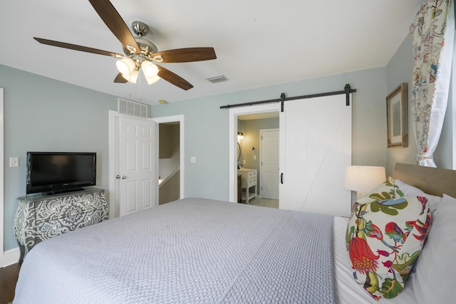 bedroom with a barn door and ceiling fan