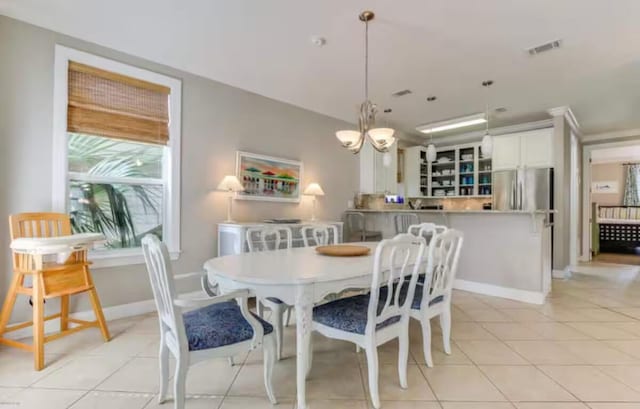 dining space featuring light tile patterned floors and a notable chandelier