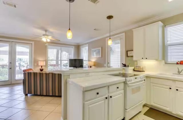 kitchen with white cabinets, pendant lighting, electric range, and kitchen peninsula