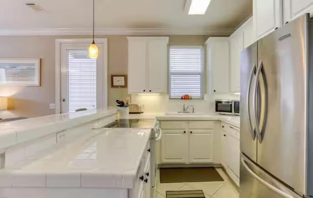 kitchen featuring crown molding, appliances with stainless steel finishes, hanging light fixtures, white cabinets, and kitchen peninsula