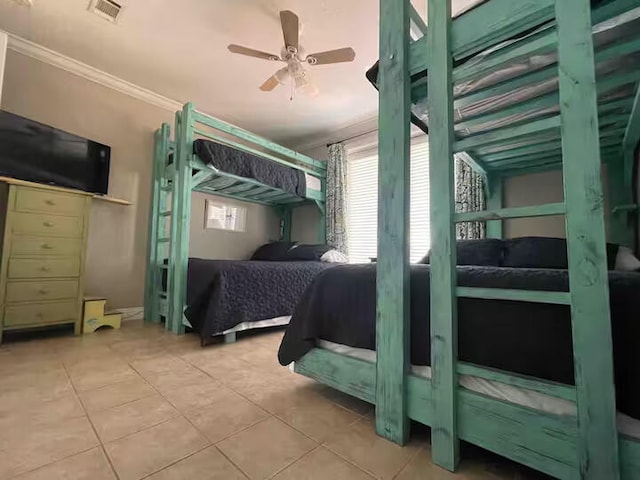 tiled bedroom with ornamental molding and ceiling fan