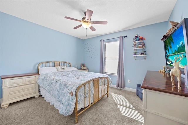 bedroom featuring light carpet, baseboards, a ceiling fan, and a textured ceiling