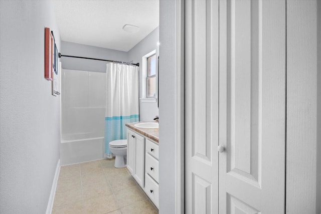 bathroom with tile patterned flooring, toilet, vanity, baseboards, and shower / bath combo