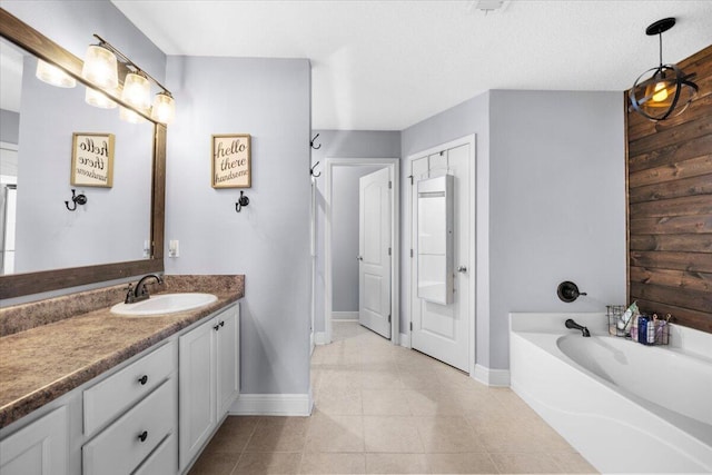 bathroom featuring tile patterned flooring, a garden tub, vanity, and baseboards