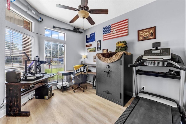 home office featuring light wood-style floors, baseboards, and a ceiling fan