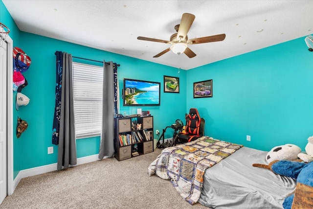 unfurnished bedroom with carpet, ceiling fan, a textured ceiling, and baseboards