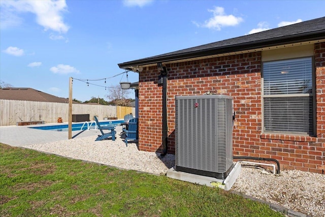 exterior space with a patio area, a fenced backyard, a fenced in pool, and central air condition unit