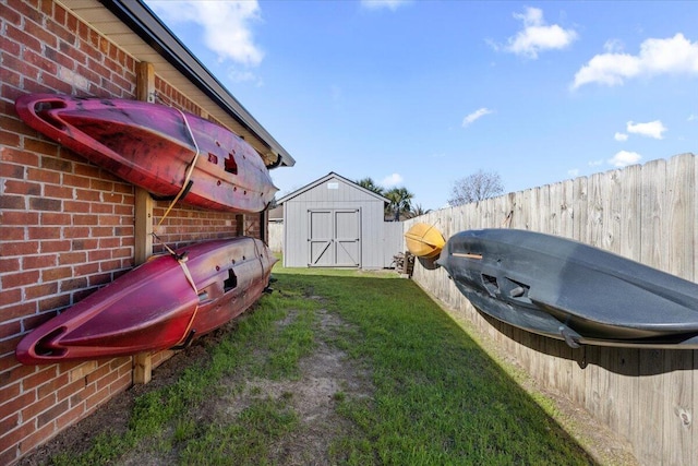 view of yard featuring a shed, an outdoor structure, and fence