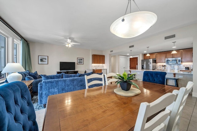 tiled dining room featuring sink and ceiling fan