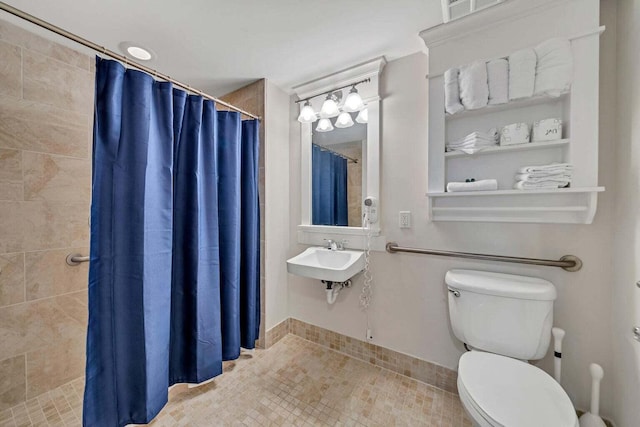 bathroom featuring tile patterned flooring, sink, toilet, and walk in shower